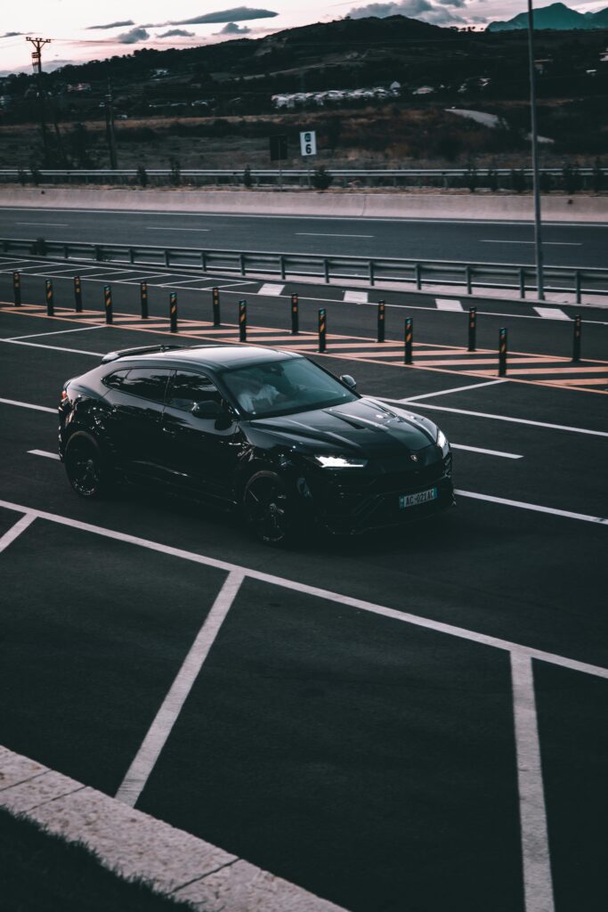 Stylish Lamborghini Urus on an empty Tirana highway during twilight, showcasing luxury and elegance.